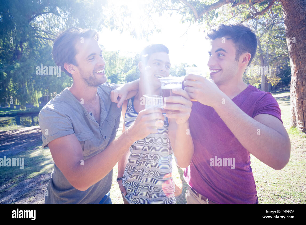 Happy friends in the park having beers Stock Photo - Alamy
