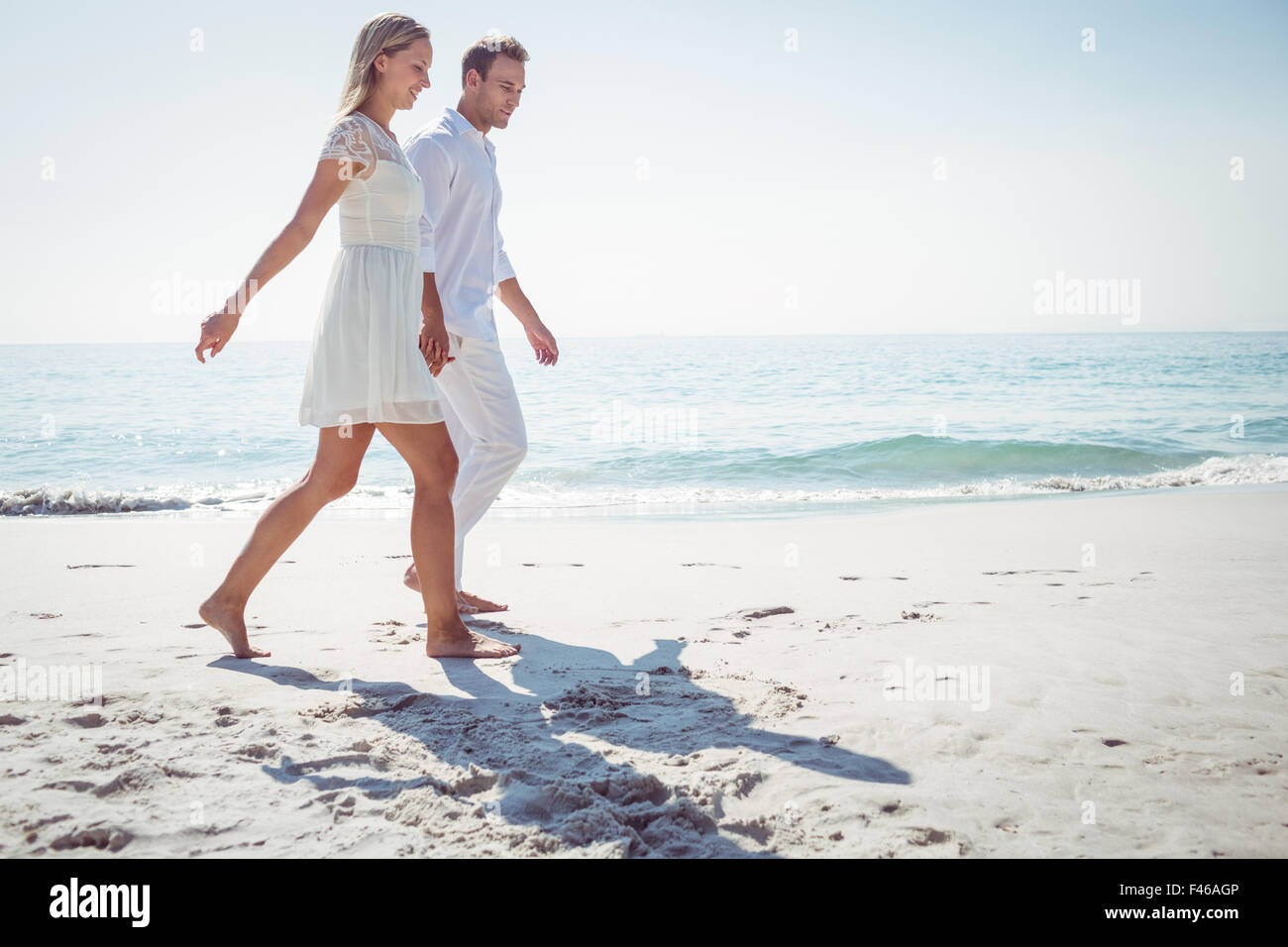Couple holding hands and standing at beach Stock Photo - Alamy