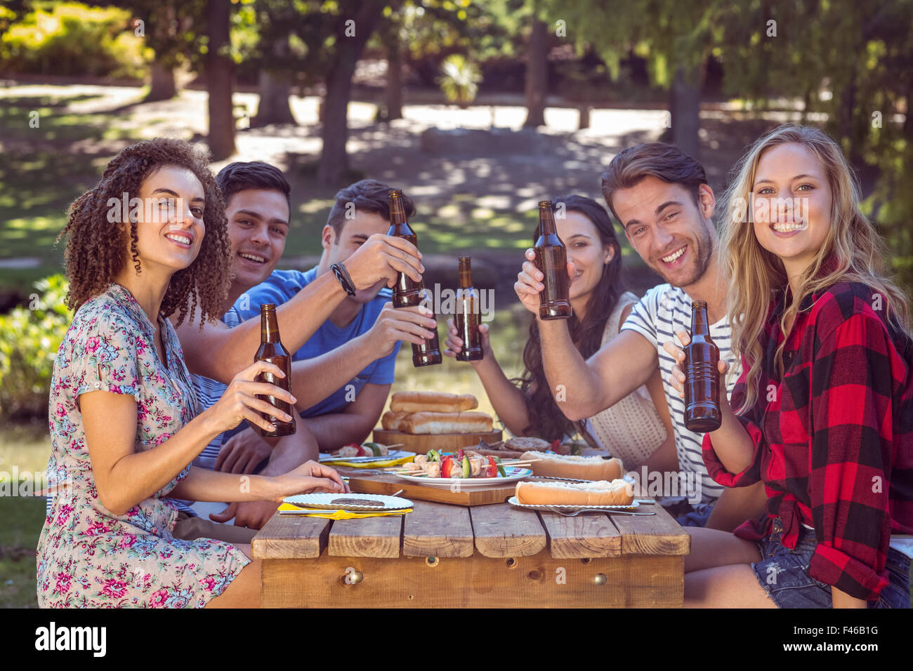 Happy friends in the park having lunch Stock Photo - Alamy