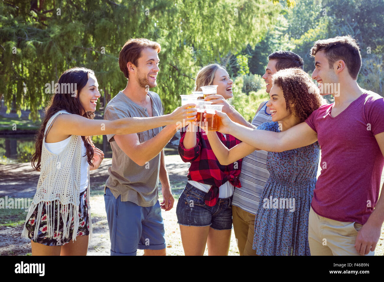 Happy friends in the park having beers Stock Photo - Alamy