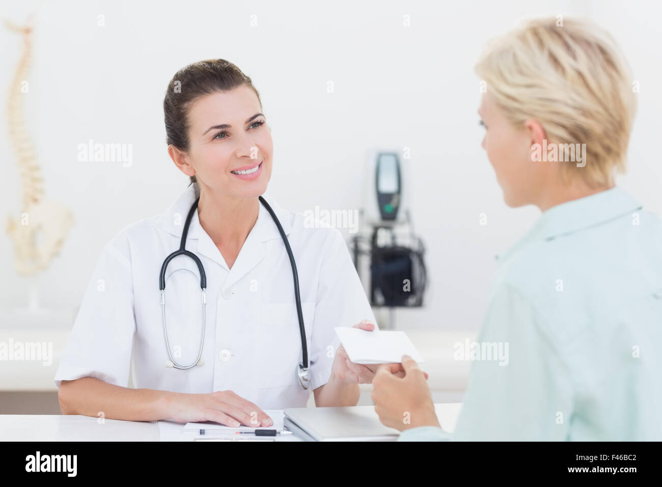 Patient giving cheque to her doctor Stock Photo - Alamy