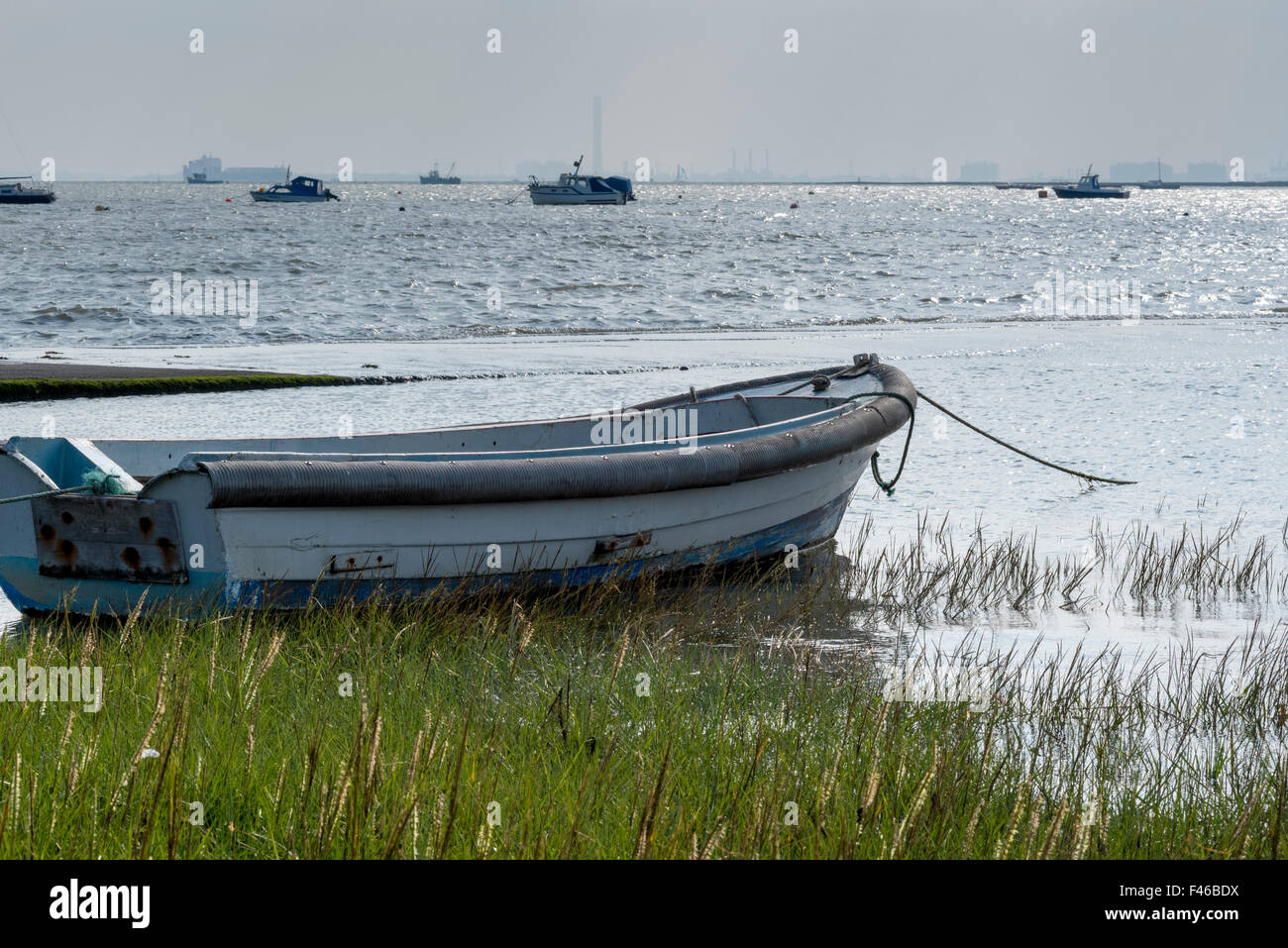 A rowing boat at high tide moored at Leigh on Sea with the Thames Estuary as a backdrop Stock Photo