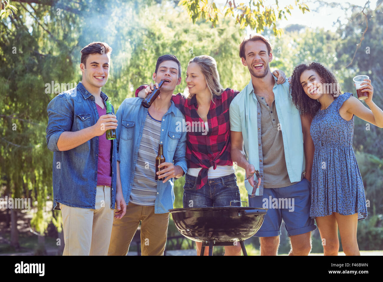 Happy friends in the park having barbecue Stock Photo - Alamy