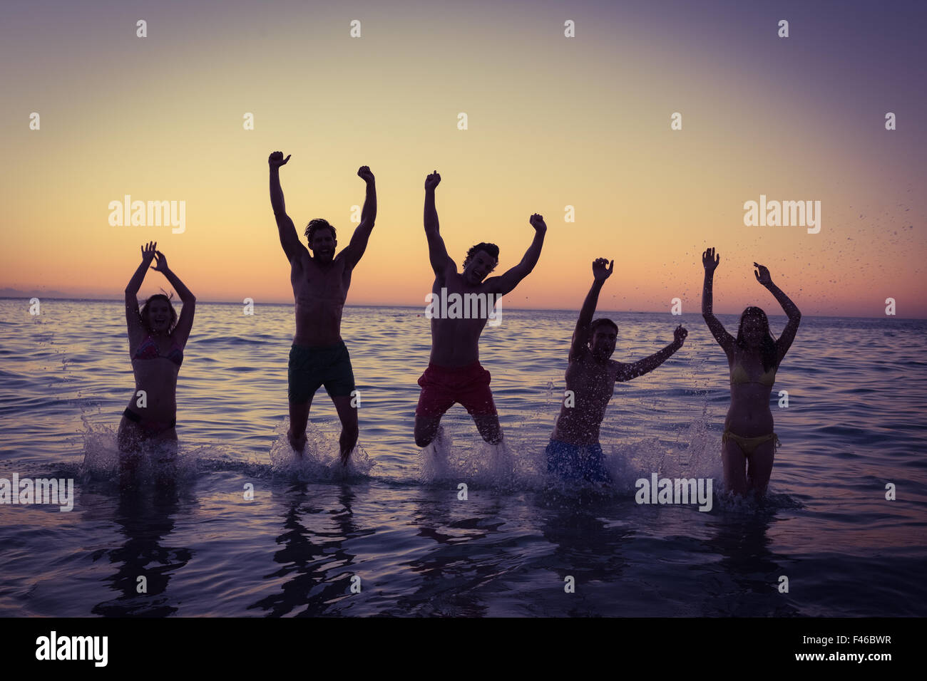 Happy friends jumping together Stock Photo - Alamy