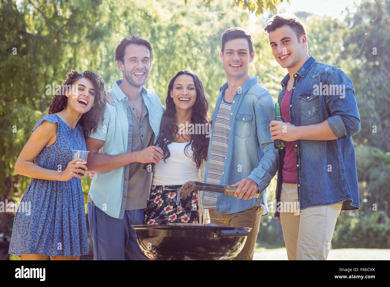 Happy friends in the park having barbecue Stock Photo - Alamy