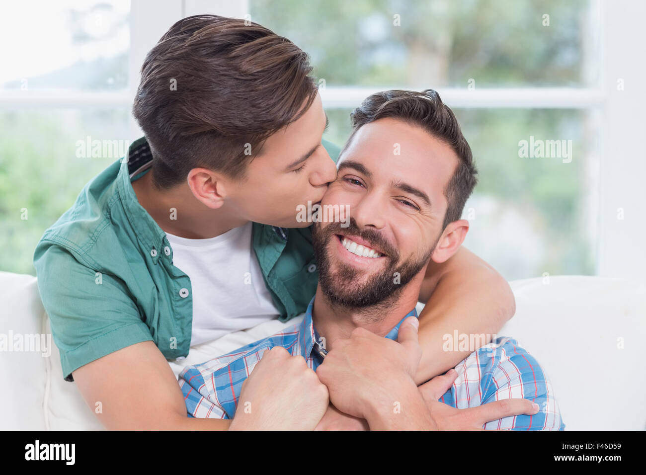 Smiling homosexual couple men kissing each other Stock Photo