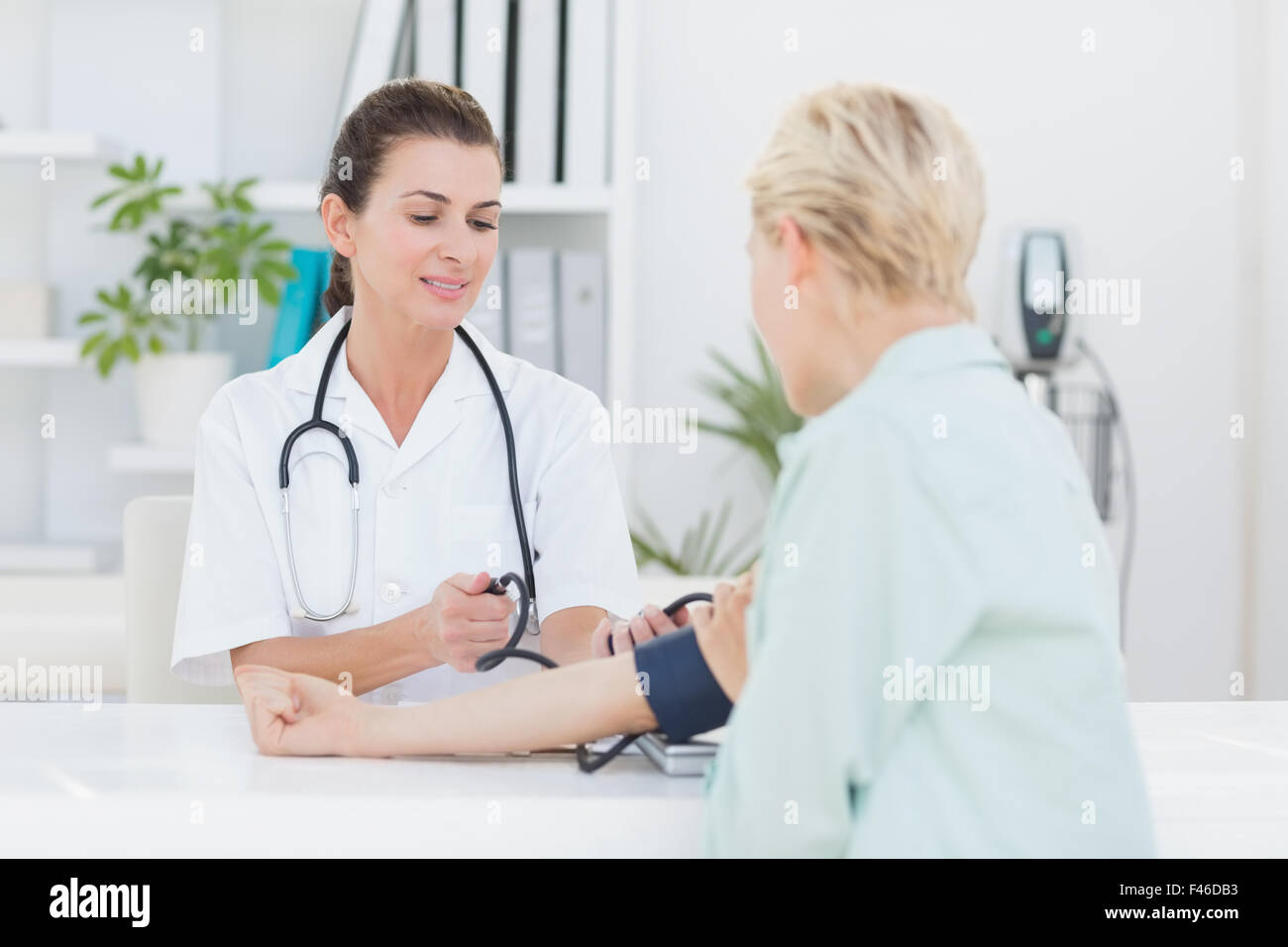 Doctor taking blood pressure of her patient Stock Photo Alamy