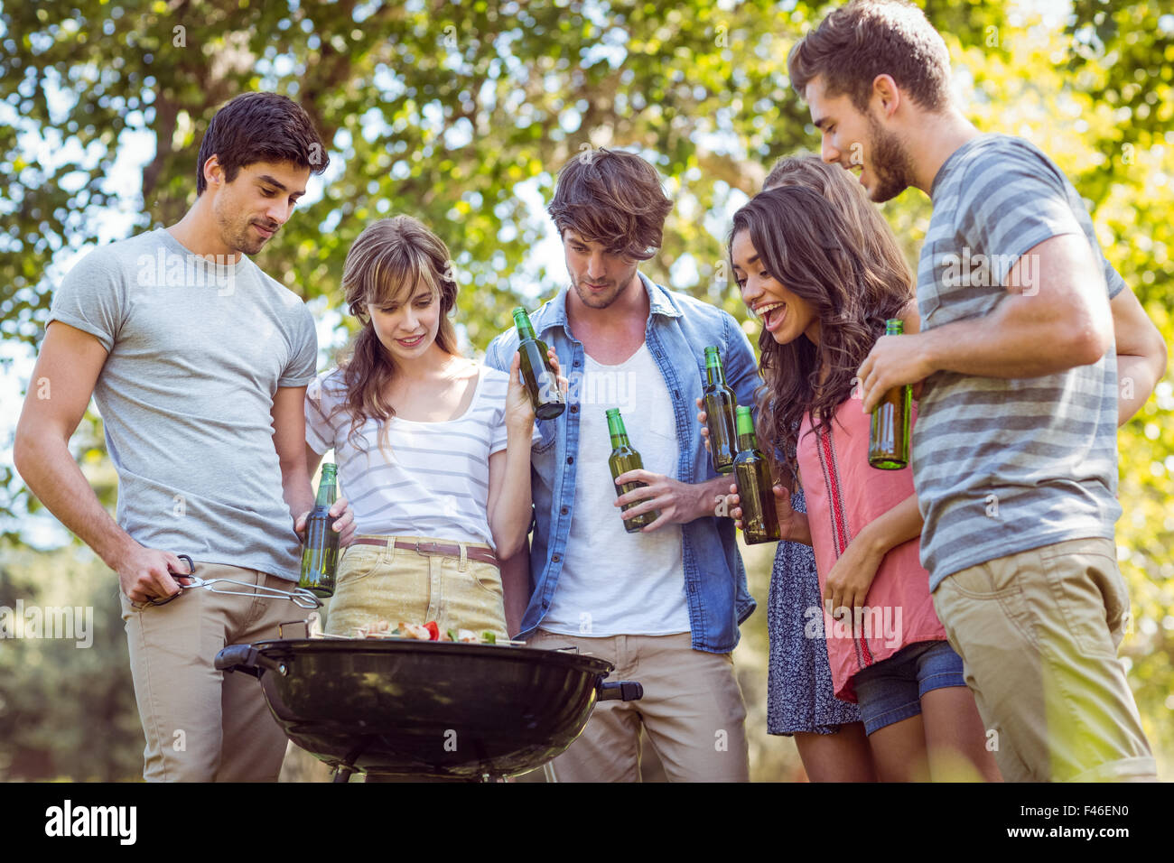 Happy friends in the park having barbecue Stock Photo - Alamy