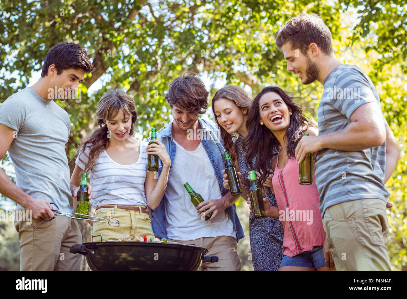 Happy friends in the park having barbecue Stock Photo - Alamy