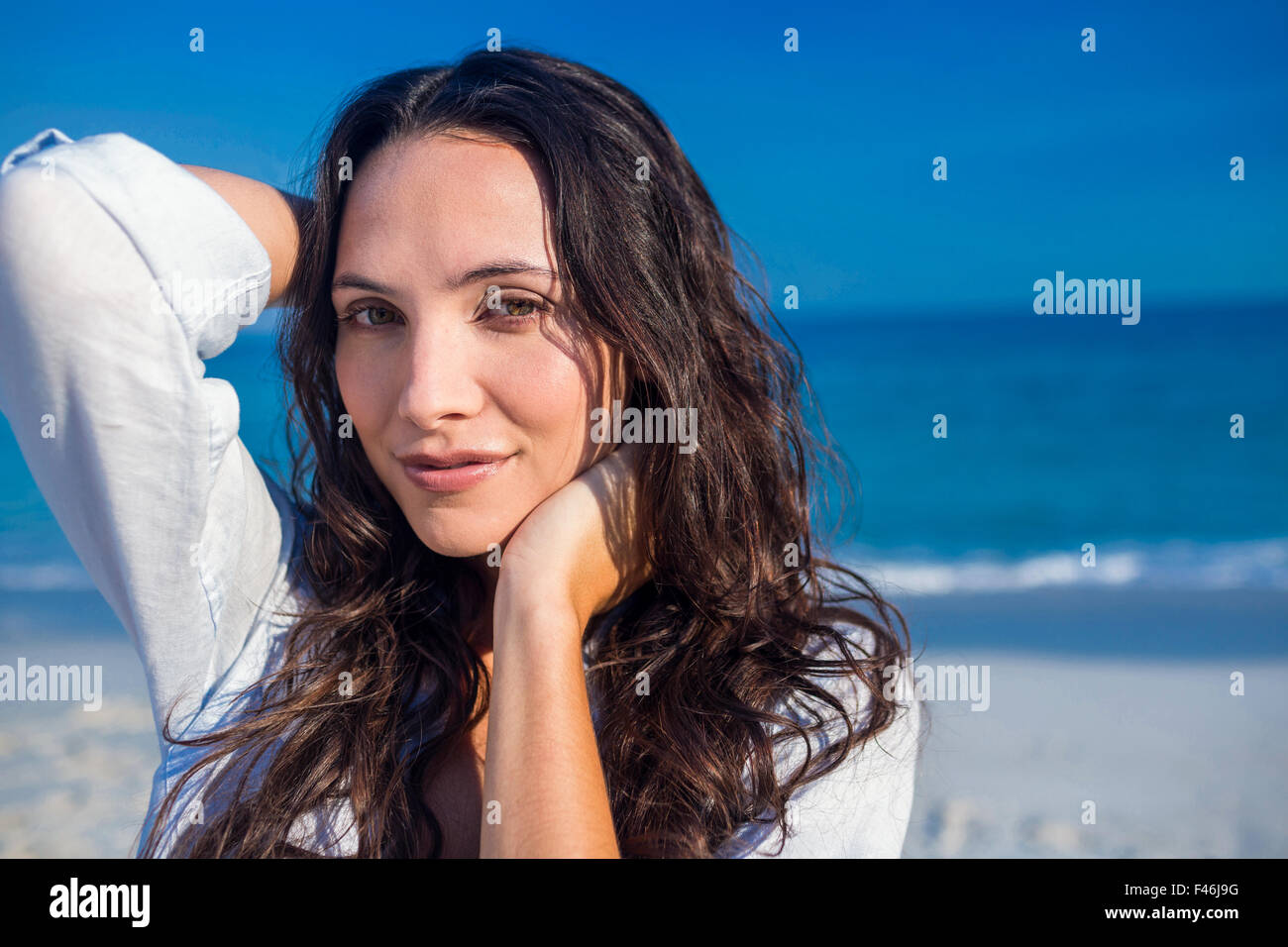 Happy woman looking at camera at the beach Stock Photo - Alamy