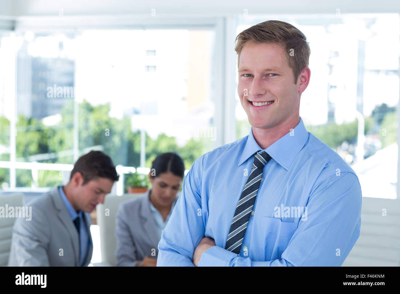 Smiling businessman with arms crossed Stock Photo - Alamy