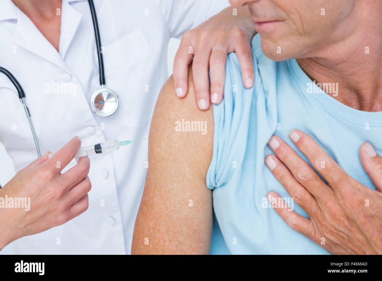 Doctor doing an injection to her patient Stock Photo - Alamy