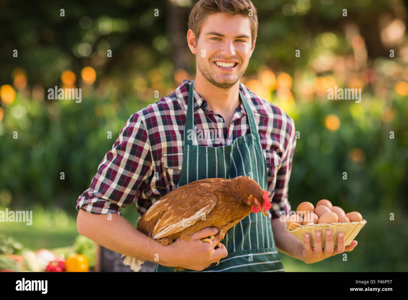 Happy farmer holding chicken and egg Stock Photo