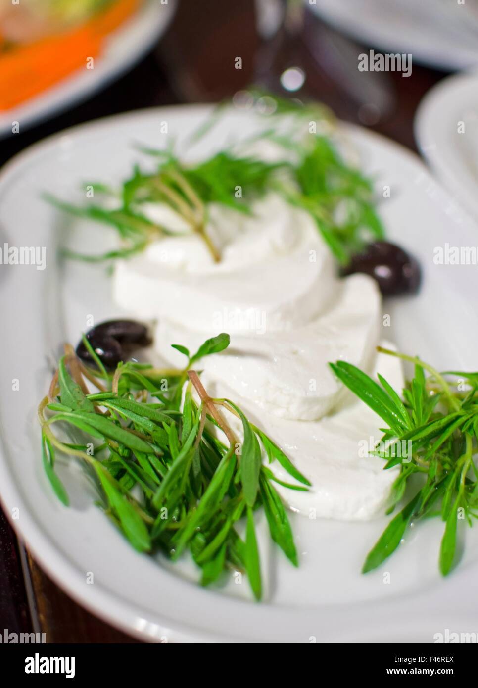 Lebanese food starter, labneh slices topped with thyme and olives. A photo of a very typical dish of Lebanon and Mediterranean c Stock Photo