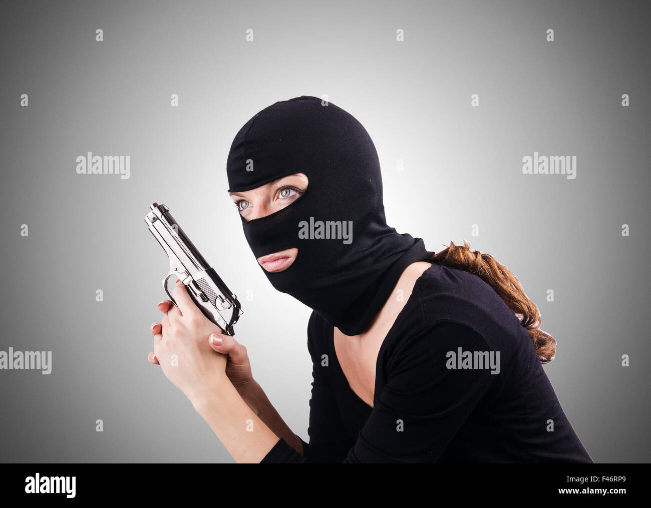 Robbery in store. Robber is aiming and threatening with gun in shop. Stock  Photo