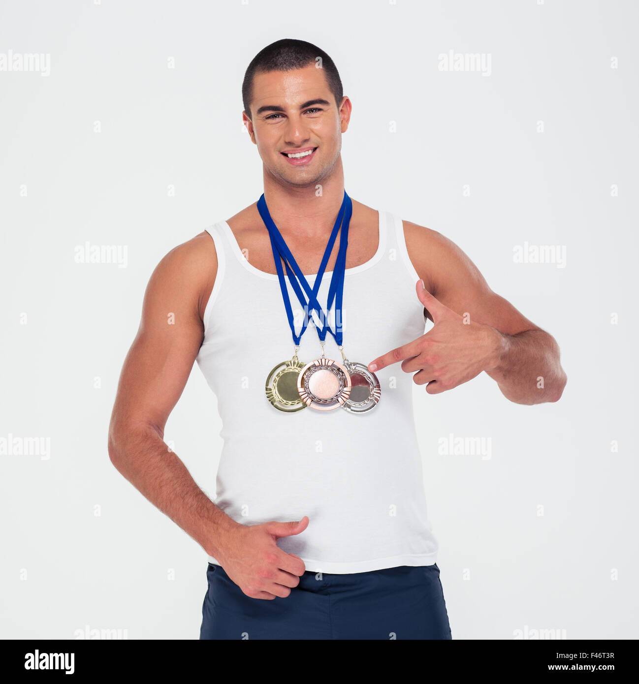 Portrait of a happy man pointing finger at his gold medals isolated on a white background Stock Photo