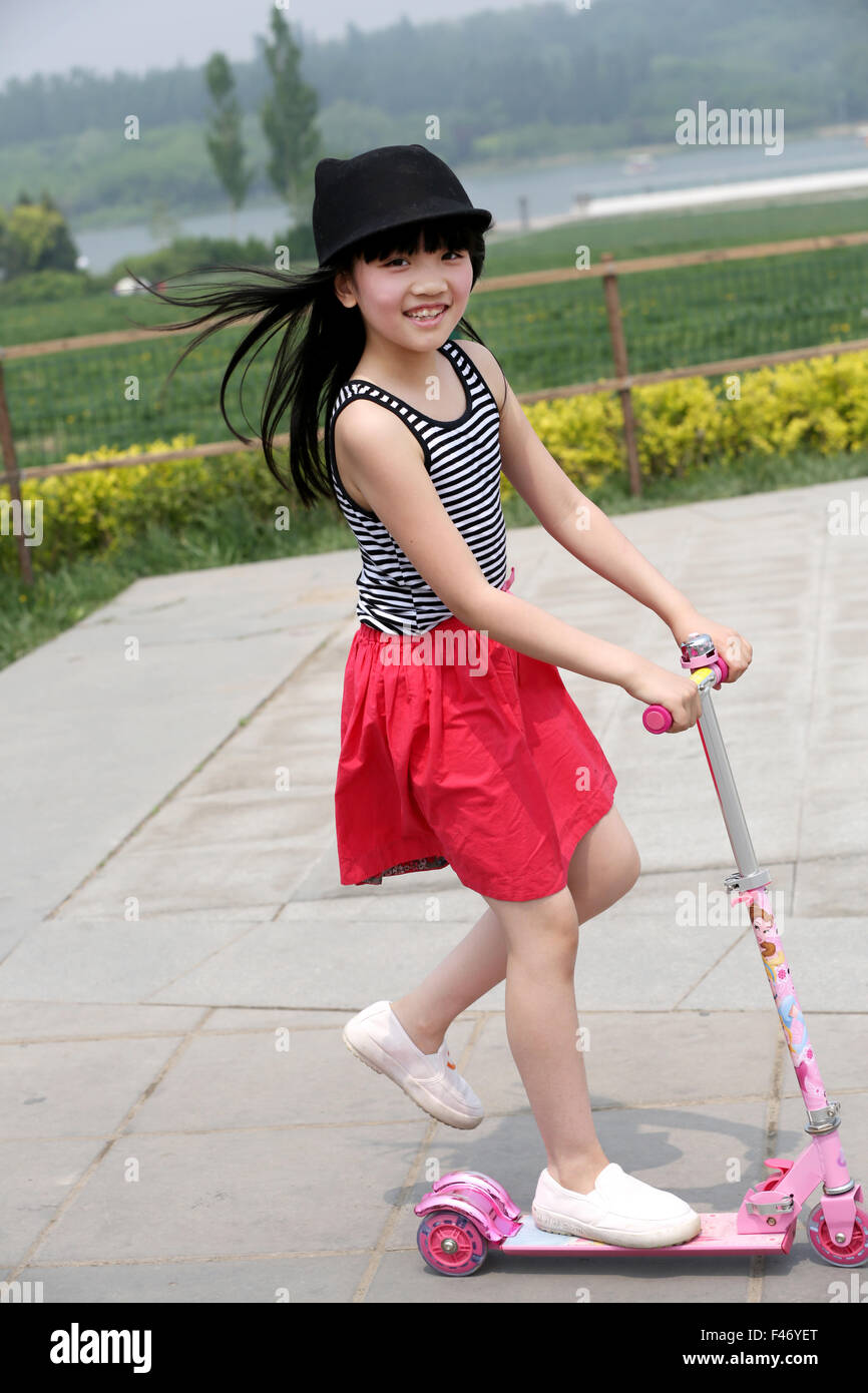 Girl riding scooter Stock Photo Alamy
