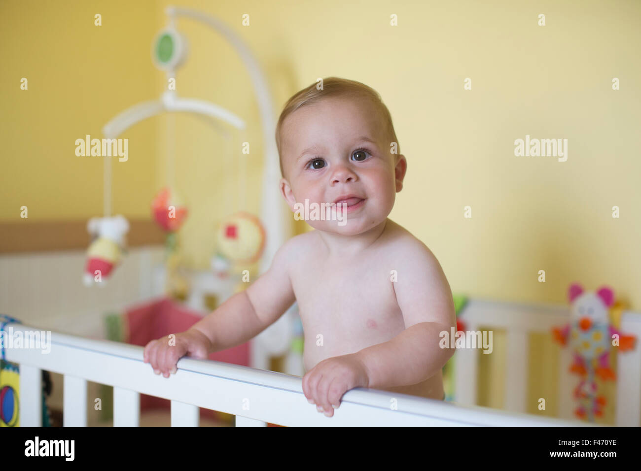 11 month old Caucasian boy, stands in his cot, London, England, United Kingdom Stock Photo