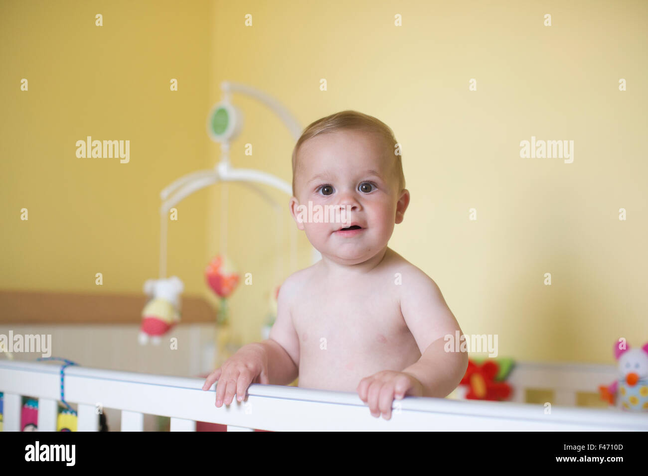 11 month old Caucasian boy, stands in his cot, London, England, United Kingdom Stock Photo
