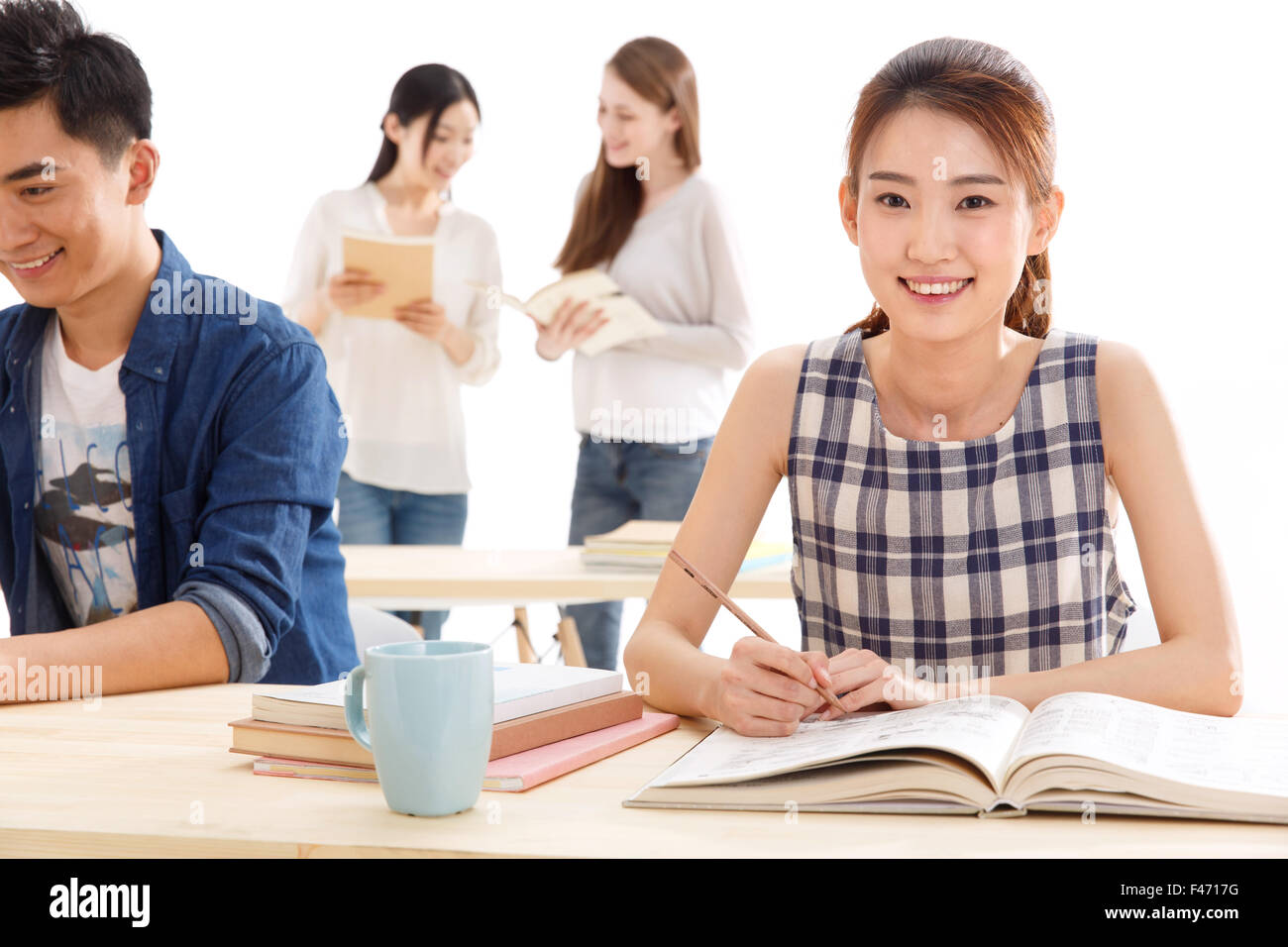 Portrait of young woman studying at table Stock Photo - Alamy