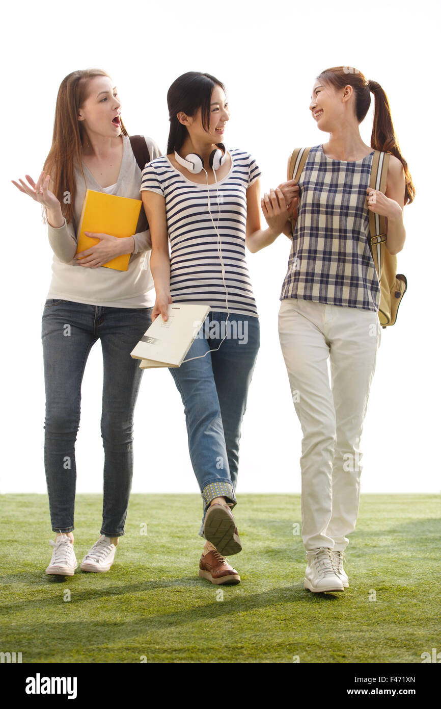 Three young woman walking side by side Stock Photo - Alamy