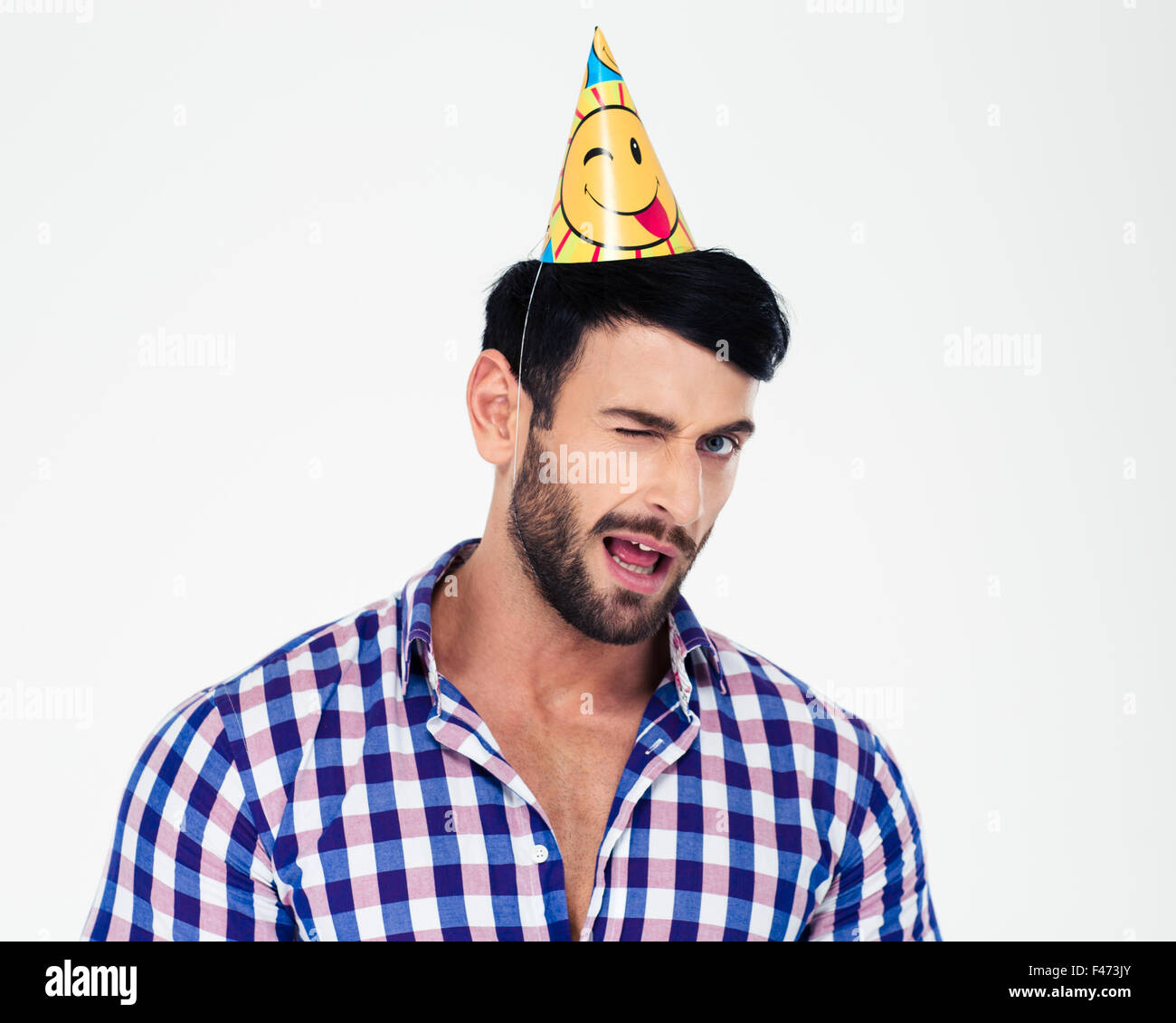 Portrait of a handsome man in birthday hat winking isolated on a white background Stock Photo