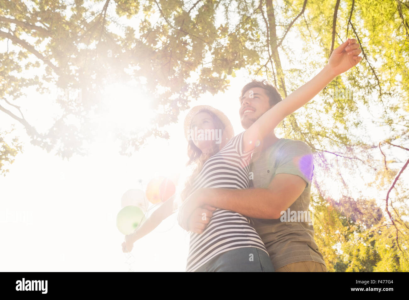 Cute couple hugging and holding balloons in the park Stock Photo - Alamy