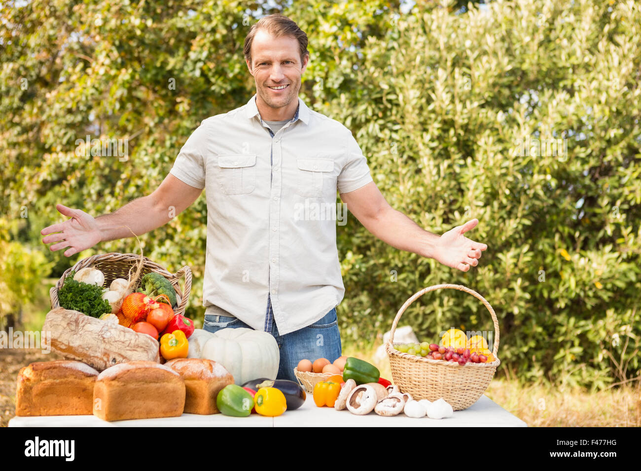 Smiling farmer holding a basket of vegetables Stock Photo - Alamy