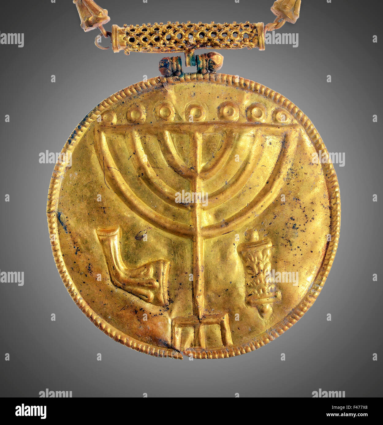 5812. Golden medallion decorated with a seven branched menorah (candelabra), a ram’s horn and a Torah scroll. The medallion dati Stock Photo