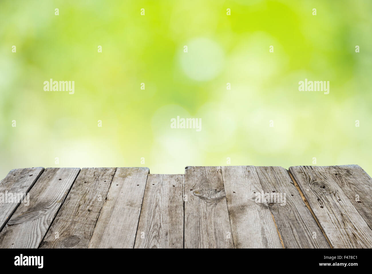 Empty wooden table with foliage bokeh Stock Photo - Alamy