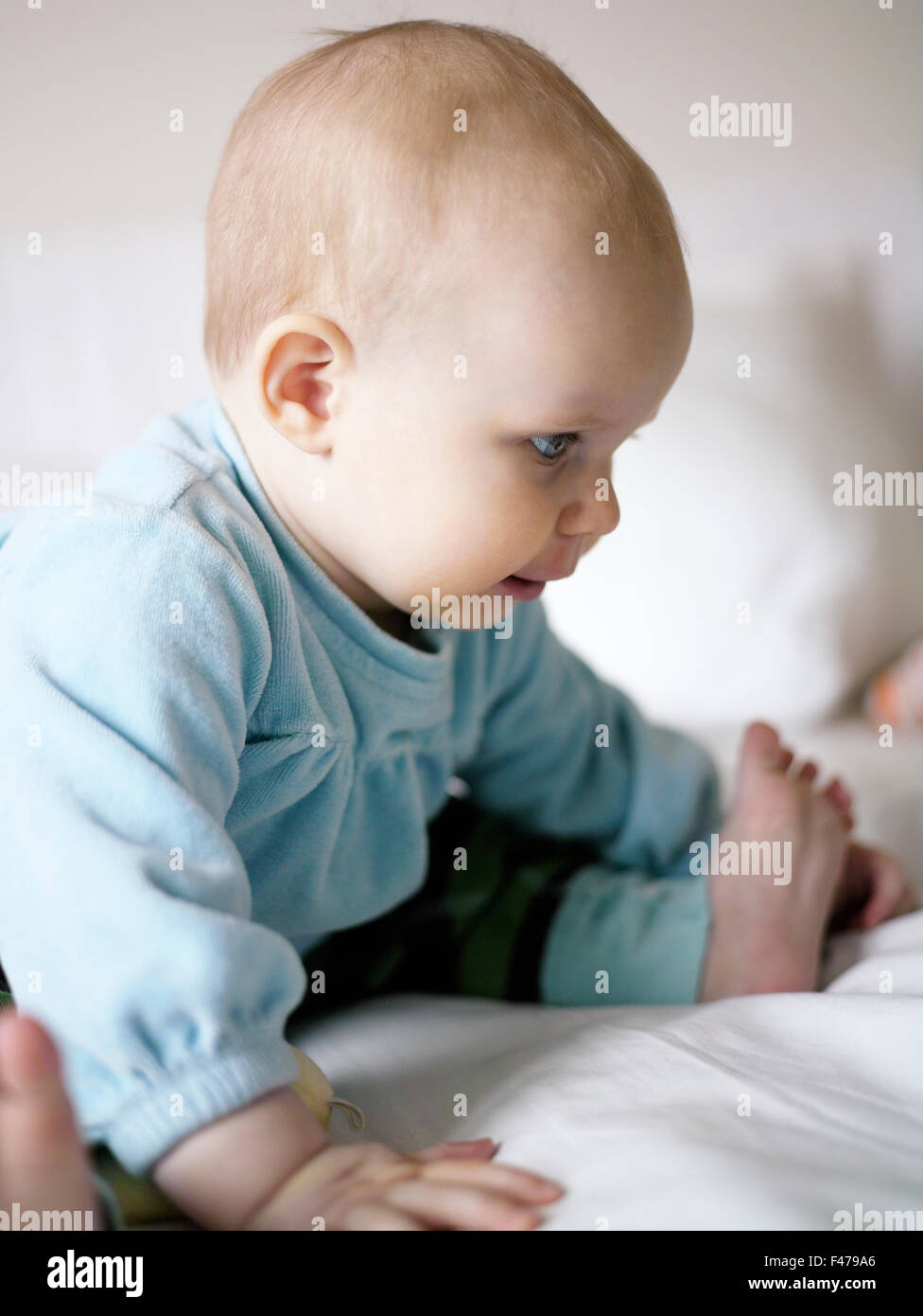 Baby sitting in baby grow hi-res stock photography and images - Alamy