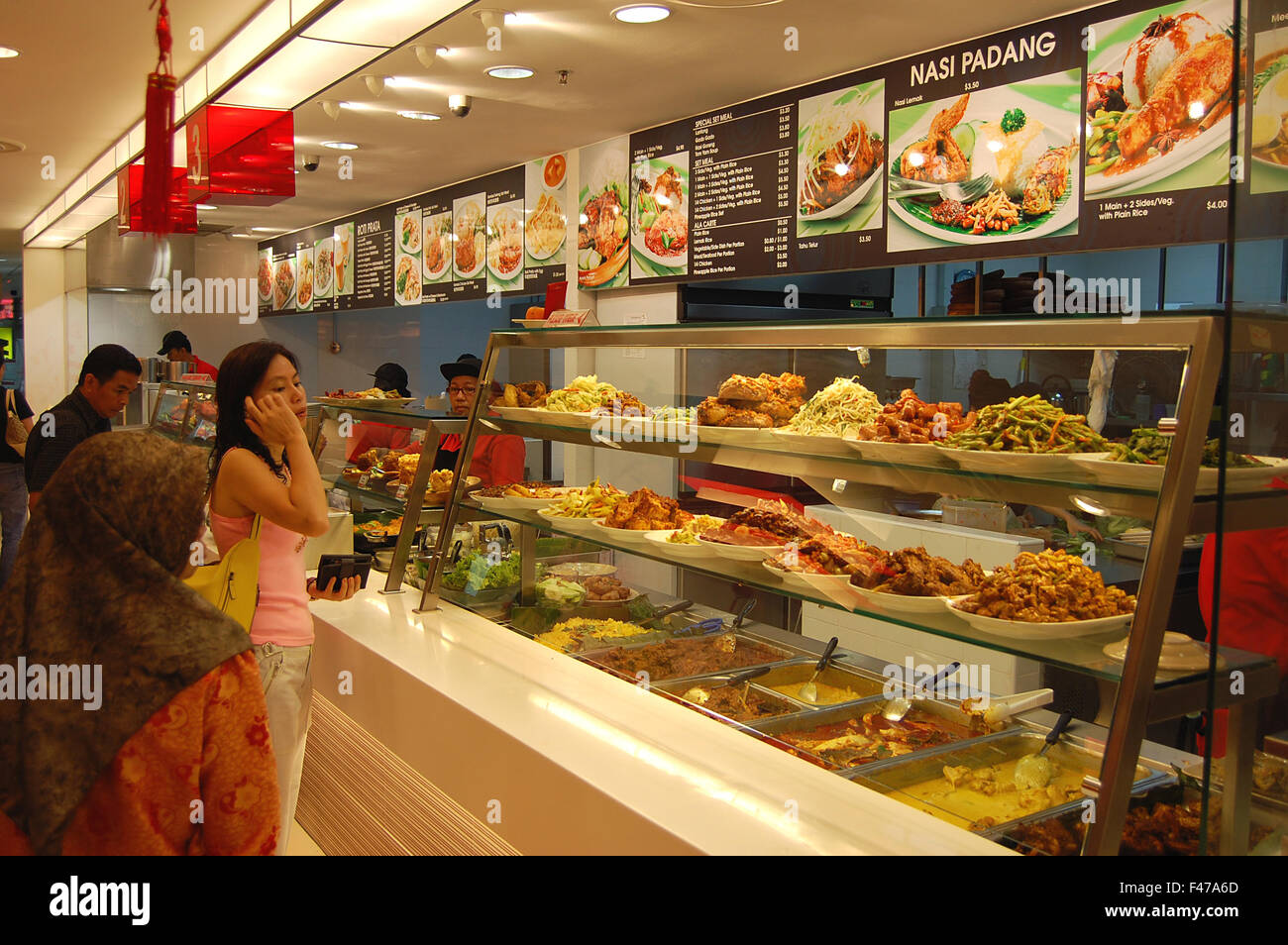 People buying Malaysian and Singaporean food at a food hall in Singapore Stock Photo