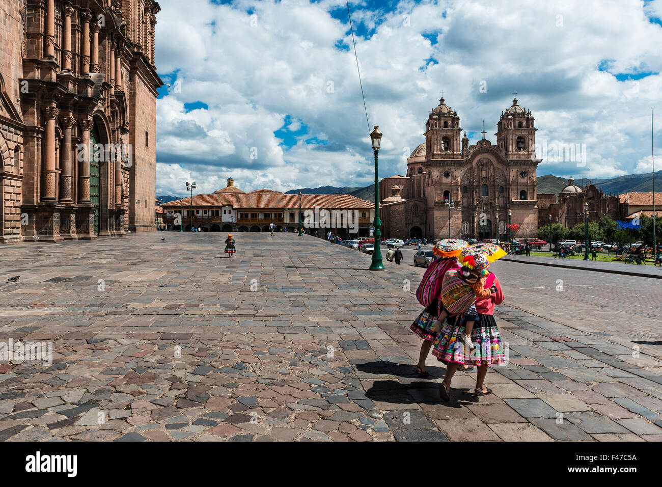 Two local women wearing traditional cloths walking in the Plaza de Armas, in Cusco, Peru, 2013 Stock Photo
