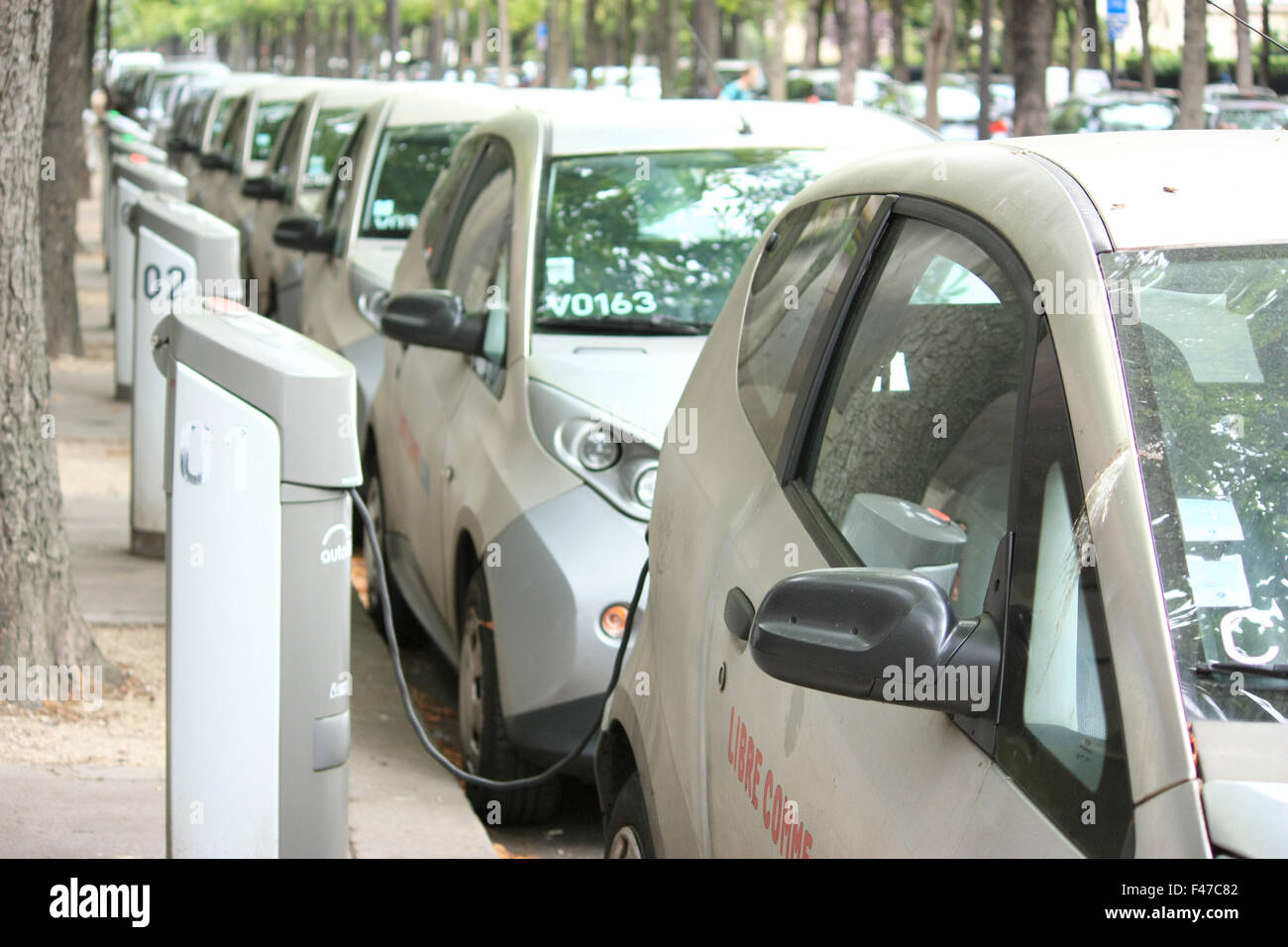 Row of electrically operated cars in unidentified street in Paris Stock Photo