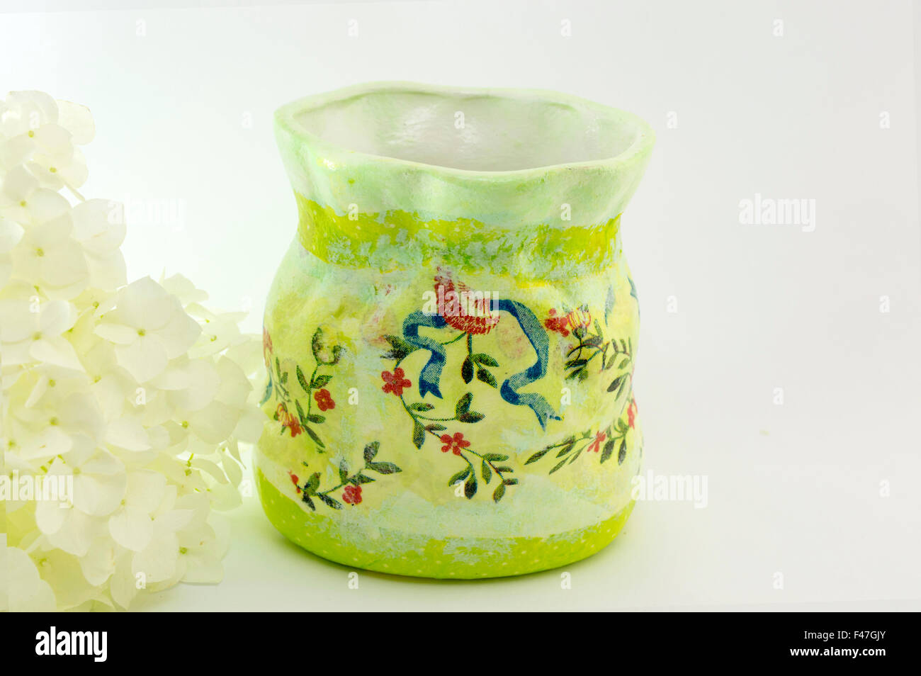 Decoupage decorated flower pattern jar with flowers on white background Stock Photo