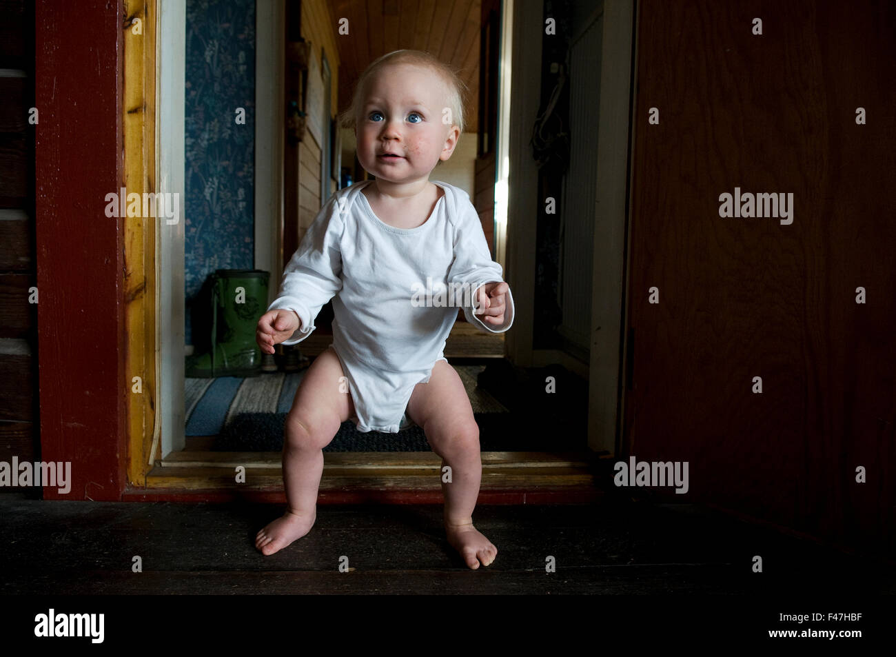 A boy standing in a doorway, Sweden. Stock Photo