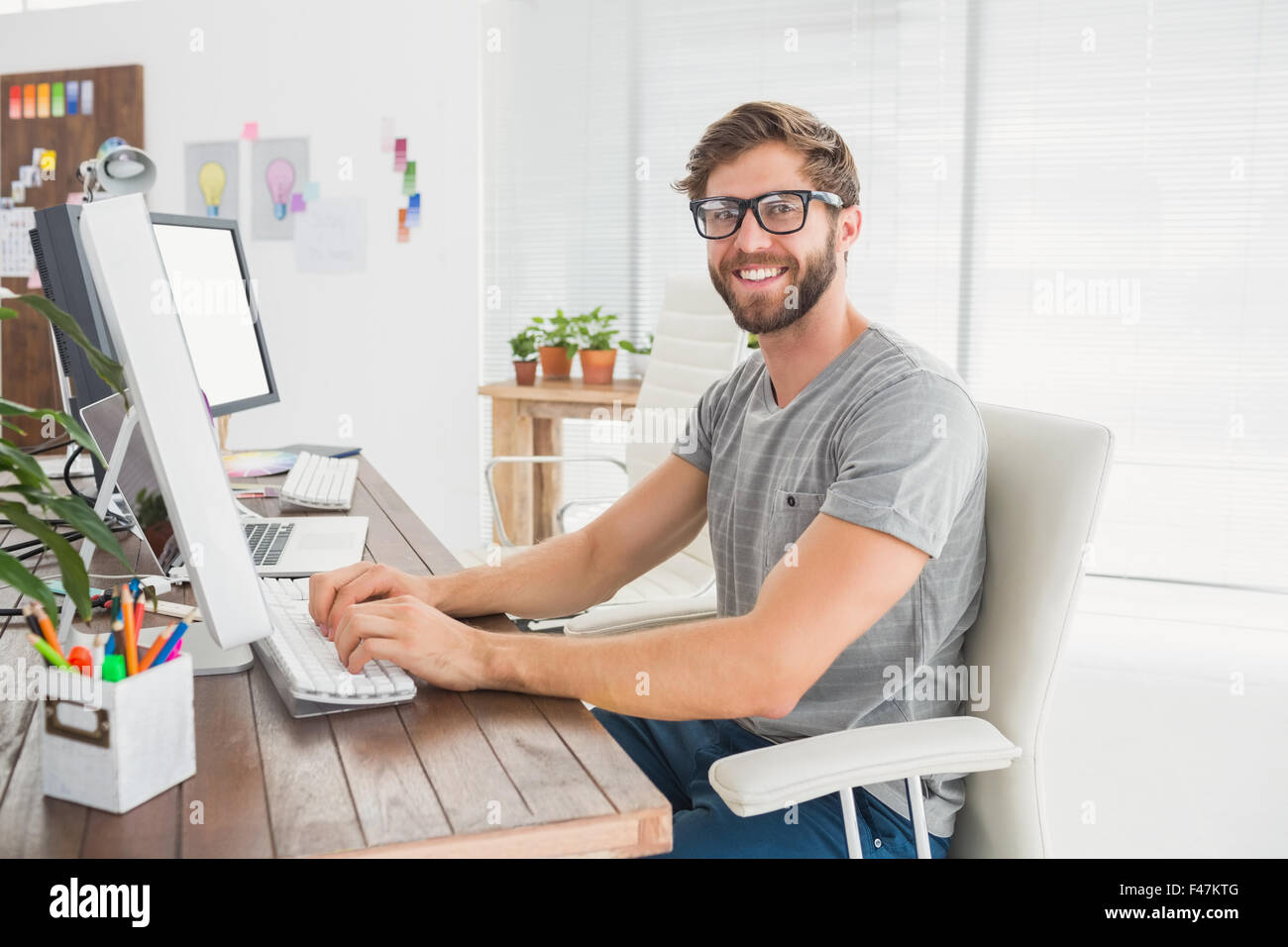 Handsome businessman sitting on a swivel chair and using his laptop ...