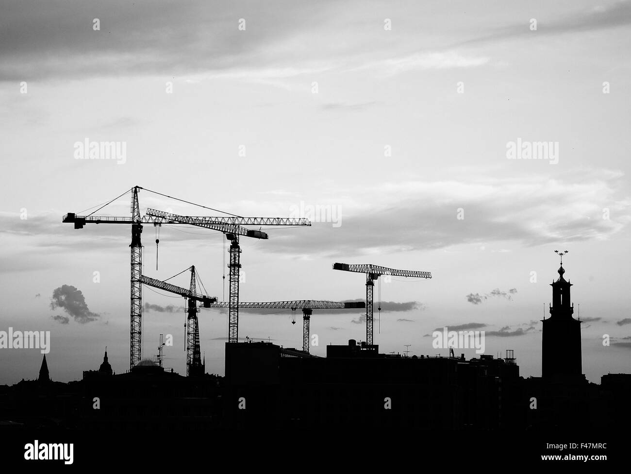 The silhouette of building cranes and the Stockholm City Hall, Sweden. Stock Photo