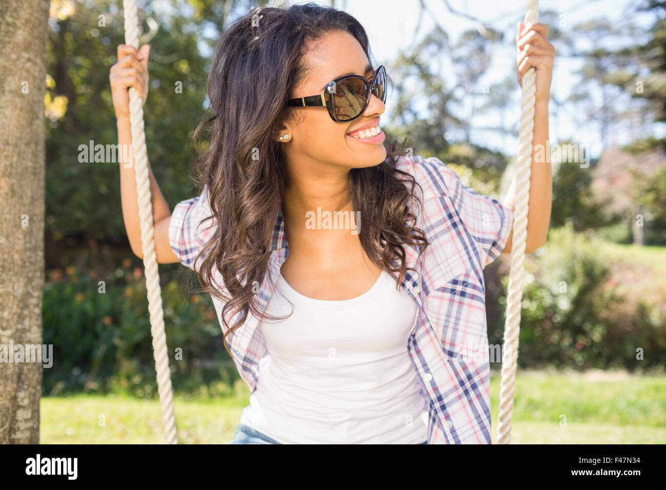 Pretty brunette swinging in park Stock Photo - Alamy