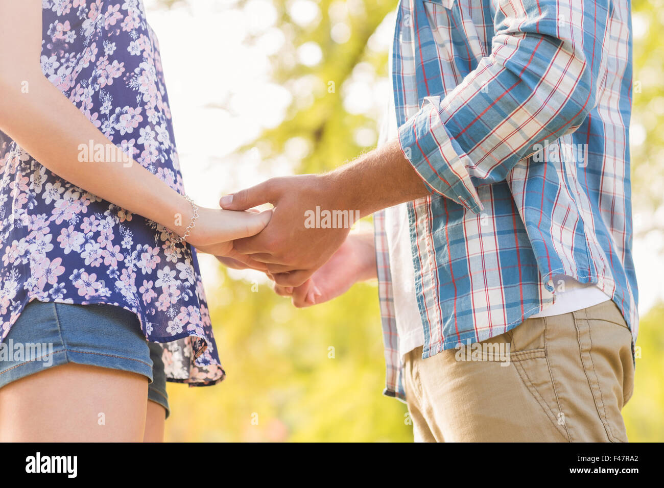 Cute couple holding hands in the park Stock Photo - Alamy