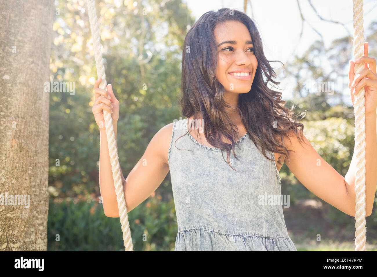 Pretty brunette swinging in park Stock Photo - Alamy