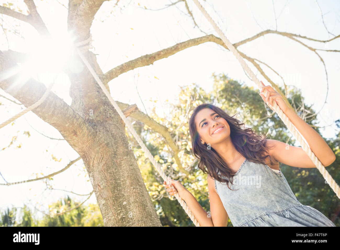 Pretty brunette swinging in park Stock Photo - Alamy