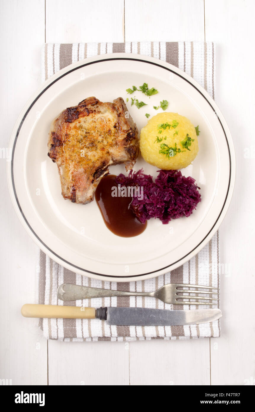 pork chop with red cabbage, gravy and potato dumpling on a plate Stock Photo