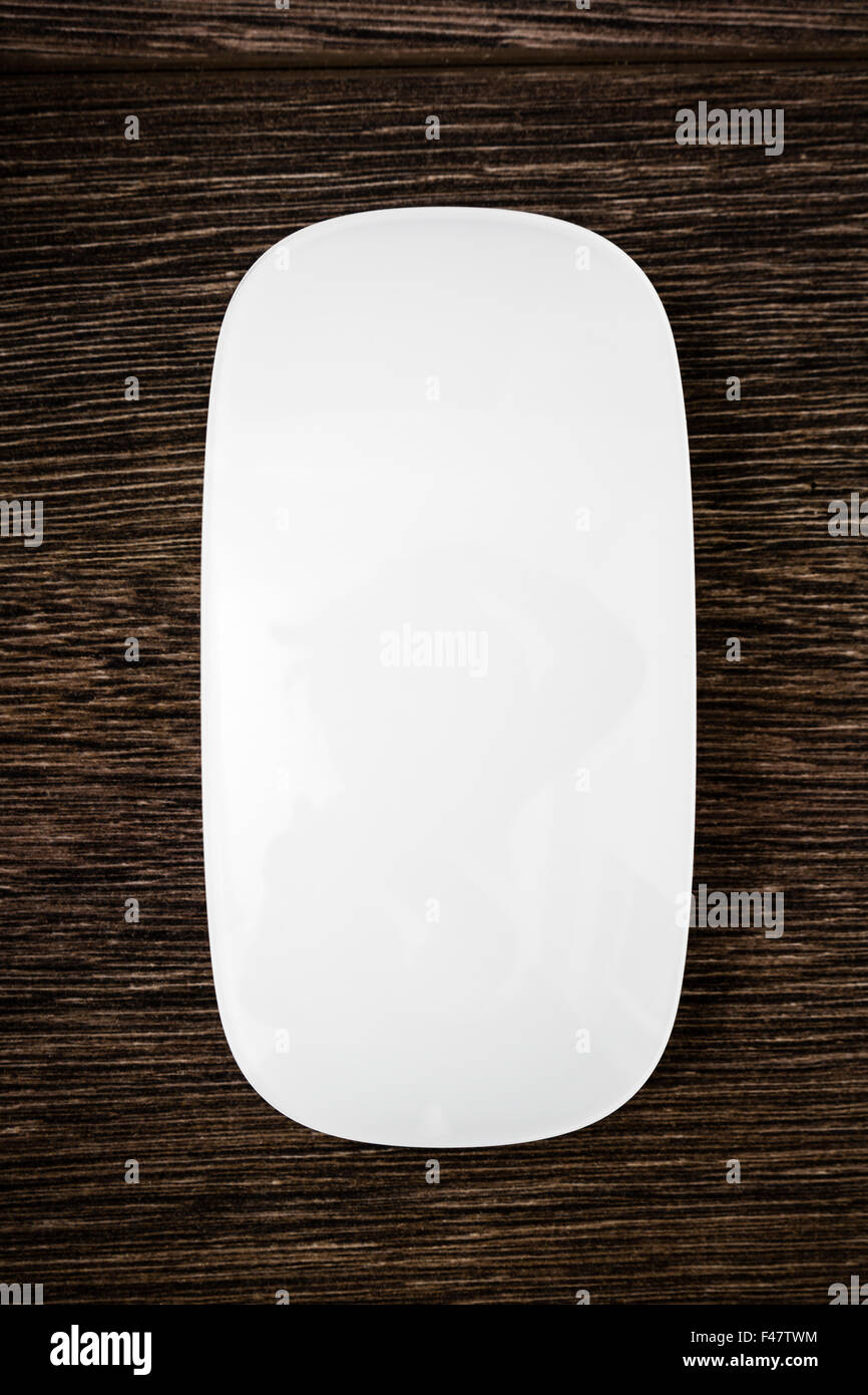 Wireless white modern computer mouse on wooden background Stock Photo