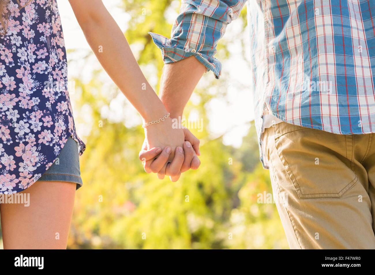 Cute couple holding hands in the park Stock Photo - Alamy