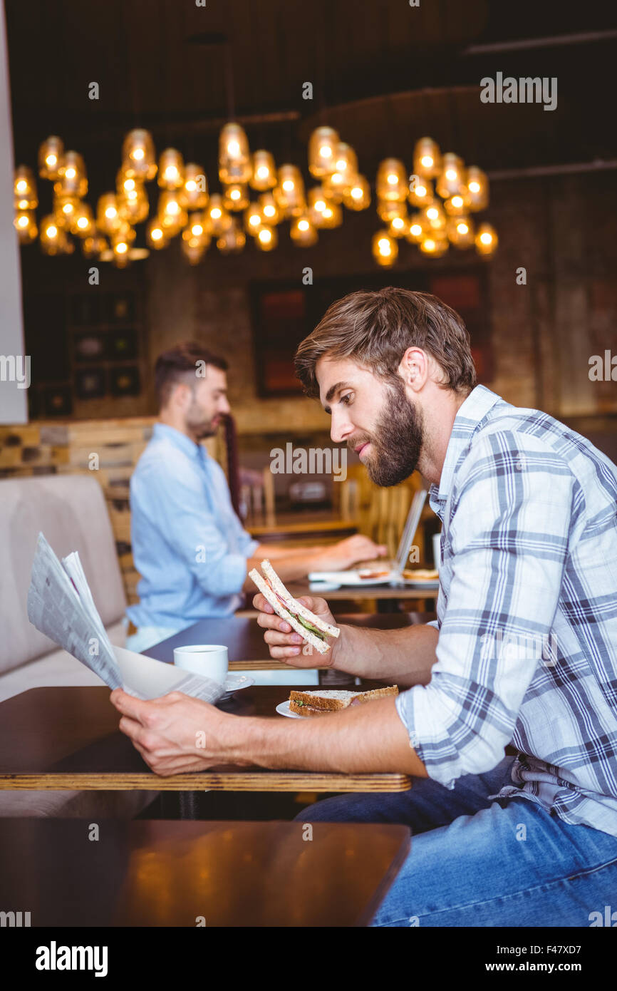 Young man reading a newspaper Stock Photo - Alamy
