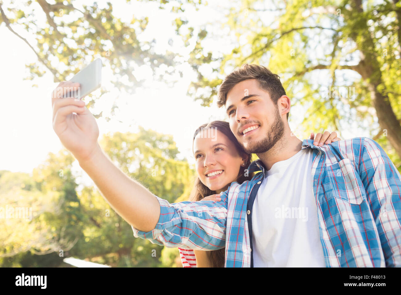 Cute couple doing selfie in the park Stock Photo - Alamy