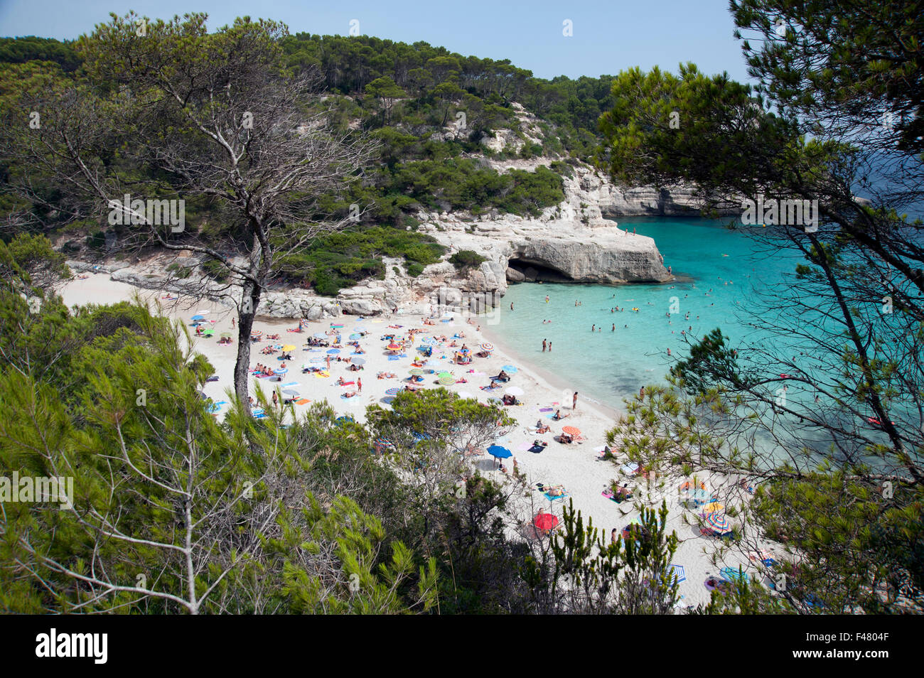 The clear azure waters of cala Mitjana from the cliffs above on the island of Menorca Spain Stock Photo