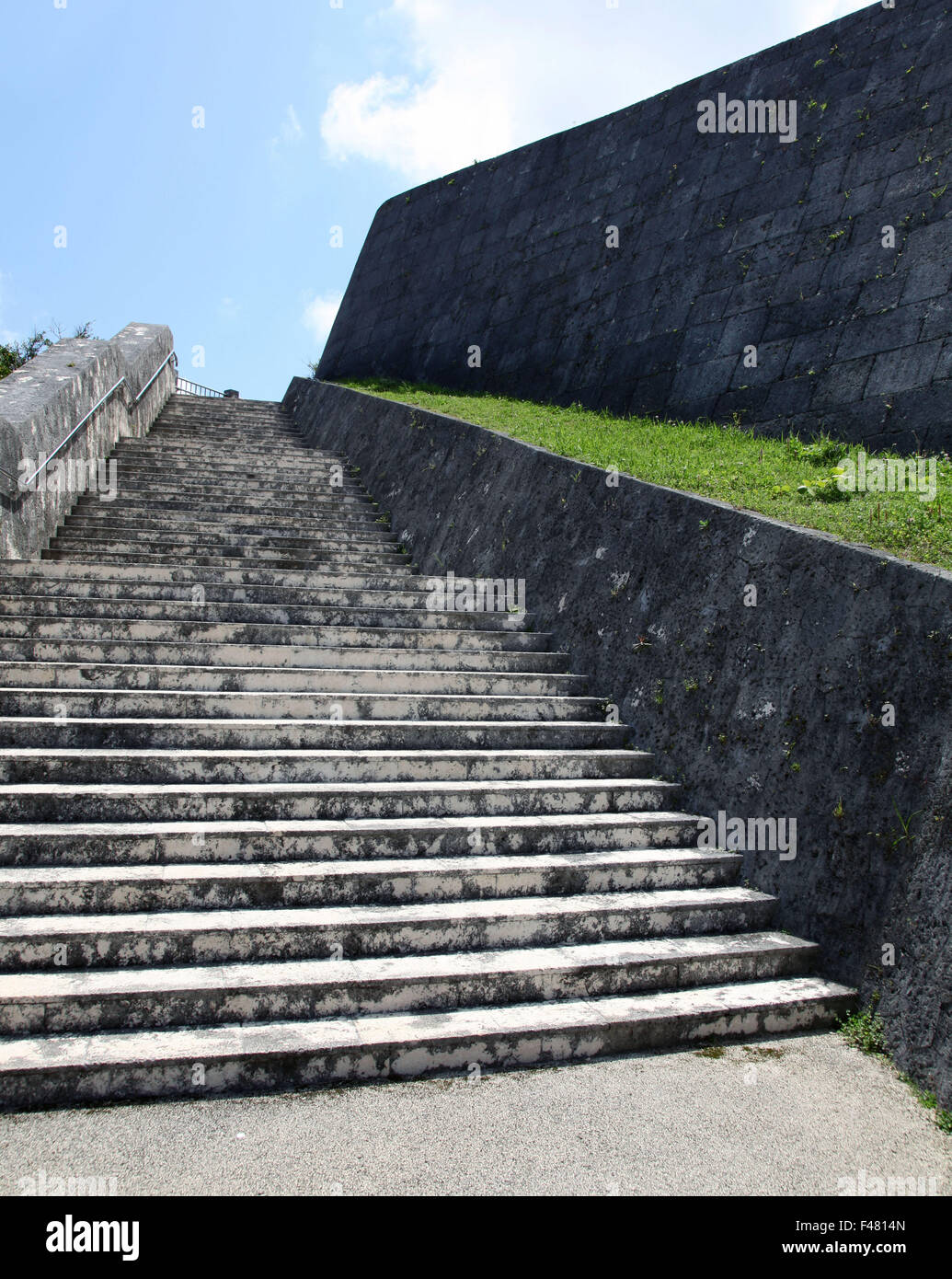 It's a photo of stone steps that go up to a park in Japan. it is near a wall of a fortress Stock Photo