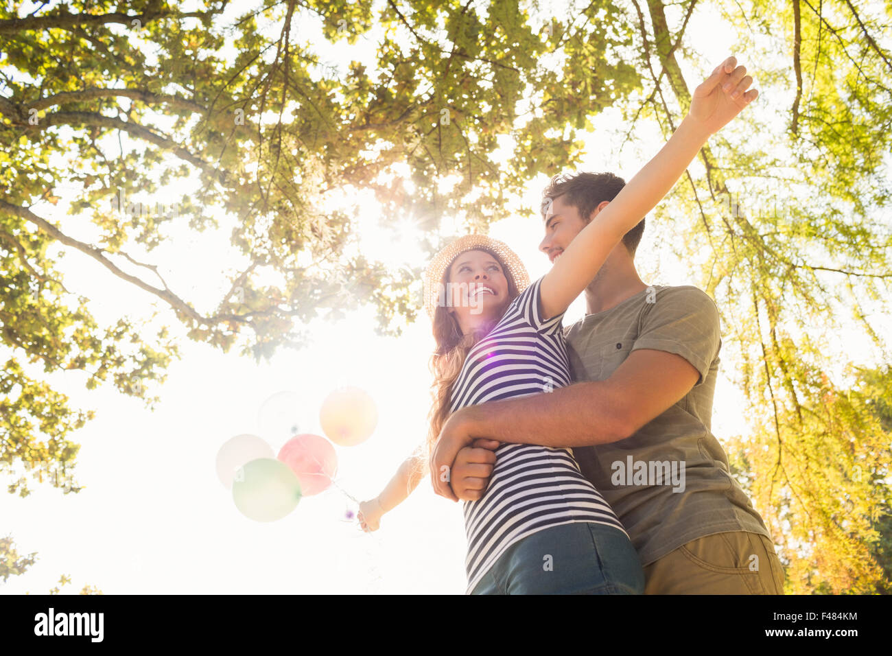 Cute couple hugging and holding balloons in the park Stock Photo - Alamy